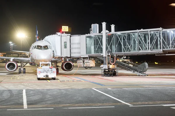 Riga, Lettland - 11. Dezember 2019. riga internationaler flughafen, rix. modernes weißes Passagierflugzeug, das nachts auf einem Parkplatz steht und sich auf das Boarding der Passagiere am internationalen Flughafen vorbereitet. — Stockfoto