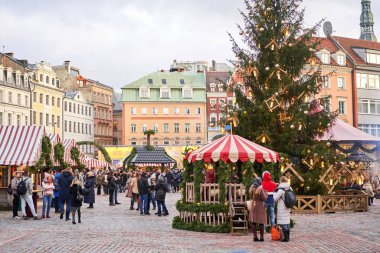 Riga, Letonya - 09 Aralık 2019. Eski Şehir 'de, Kubbe Meydanı' ndaki Noel pazarında. İnsanlar Avrupa 'daki bir Noel pazarından geleneksel hediyeler alıyorlar. Yılbaşı hediyeleri satarak evleri takas etmek..