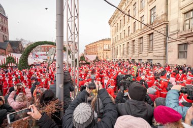 Riga, Letonya - 08 Aralık 2019. Eski Şehir 'de, Kubbe Meydanı' ndaki Noel pazarında. İnsanlar Avrupa 'daki bir Noel pazarından geleneksel hediyeler alıyorlar. Yılbaşı hediyeleri satarak evleri takas etmek..