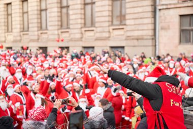 Riga, Letonya - 08 Aralık 2019. Eski Şehir 'de, Kubbe Meydanı' ndaki Noel pazarında. İnsanlar Avrupa 'daki bir Noel pazarından geleneksel hediyeler alıyorlar. Yılbaşı hediyeleri satarak evleri takas etmek..