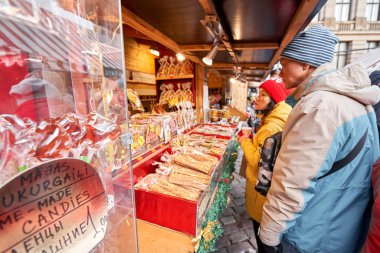Riga, Letonya - 08 Aralık 2019. Eski Şehir 'de, Kubbe Meydanı' ndaki Noel pazarında. İnsanlar Avrupa 'daki bir Noel pazarından geleneksel hediyeler alıyorlar. Yılbaşı hediyeleri satarak evleri takas etmek..
