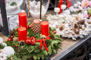 Avrupa çiçekçisinin çeşitli ürünleri. Taze ladin güzel bir çelenk. Noel havası. Xmas ağacı. Arka planda çelenk ışıkları Bokeh