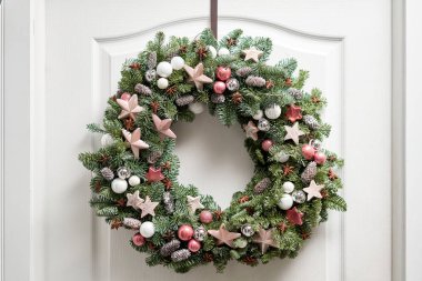 Beyaz kapıda taze ladin çelengi var. Evin girişi. Noel havası. Xmas ağacı.