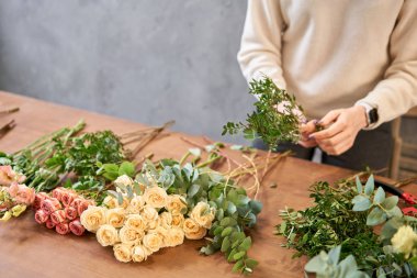 Adım adım çiçekçi kadın kırmızı güzel bir buket karışık çiçek yaratır. Yakışıklılar. Eğitim, yüksek lisans ve çiçekçilik dersleri. Çiçek teslimatı. Avrupa çiçekçi dükkânı konsepti.