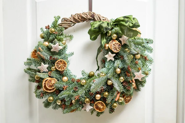 Bela coroa de Natal de abeto fresco na porta branca. Entrada para a casa. Humor de Natal. Árvore natal . — Fotografia de Stock