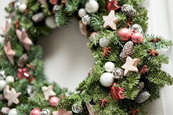 Closeup details of Beautiful Christmas wreath of fresh spruce on the white door. Entrance to the house. Christmas mood. Xmas tree. — Stock Photo, Image