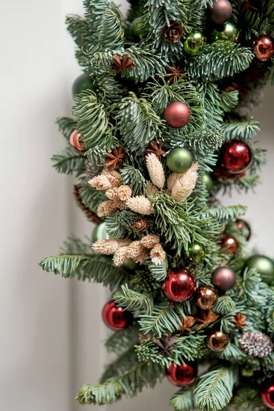Detalhes de close-up da grinalda de Natal bonita de abeto fresco na porta branca. Entrada para a casa. Humor de Natal. Árvore natal . — Fotografia de Stock