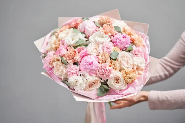 Pedónias cor-de-rosa, Sarah Bernhardt e flores diferentes. Loja floral europeia. Belo buquê em mãos de mulheres. o trabalho da florista em uma loja de flores. Entrega flor de corte fresco . — Fotografia de Stock