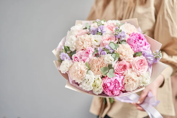 Pedónias cor-de-rosa, Sarah Bernhardt e flores diferentes. Loja floral europeia. Belo buquê em mãos de mulheres. o trabalho da florista em uma loja de flores. Entrega flor de corte fresco . — Fotografia de Stock