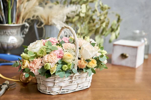 Beautiful flower composition a bouquet in a wicker basket. Floristry concept. Spring colors — Stock Photo, Image
