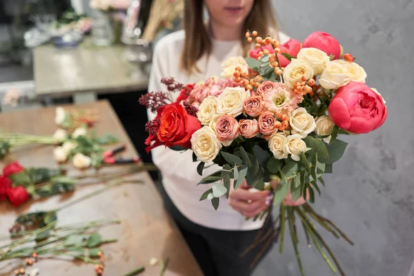 Paso a paso florista mujer crea rojo hermoso ramo de flores mixtas. Hermoso grupo fresco. Cursos de educación, master class y floristería. Entrega de flores. Concepto europeo de tienda floral . — Foto de Stock