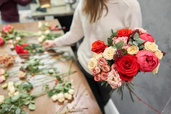 Paso a paso florista mujer crea rojo hermoso ramo de flores mixtas. Hermoso grupo fresco. Cursos de educación, master class y floristería. Entrega de flores. Concepto europeo de tienda floral . — Foto de Stock