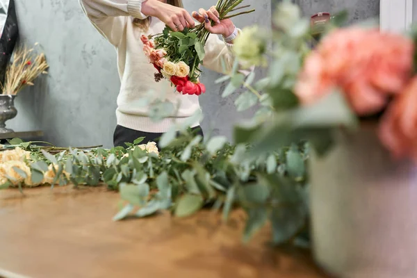 Concepto europeo de tienda floral. Florista mujer crea rojo hermoso ramo de flores mixtas. Hermoso grupo fresco. Cursos de educación, master class y floristería. Entrega de flores . — Foto de Stock