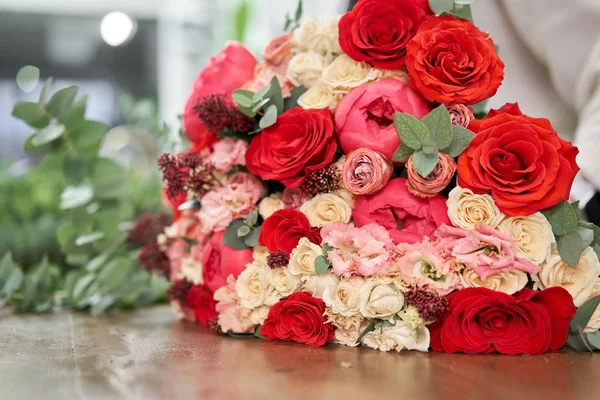 European floral shop concept. Florist woman creates red beautiful bouquet of mixed flowers. Handsome fresh bunch. Education, master class and floristry courses. Flowers delivery. — Stock Photo, Image