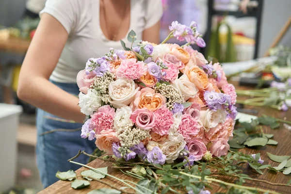 European floral shop concept. Florist woman creates beautiful bouquet of mixed flowers. Handsome fresh bunch. Education, master class and floristry courses. Flowers delivery. — стокове фото