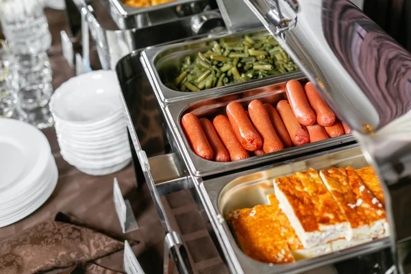 Gekookte worsten en gebakken omelet. Ontbijtbuffet in hotel. Veel verwarmde dienbladen klaar voor gebruik. Metalen containers met warme maaltijden — Stockfoto