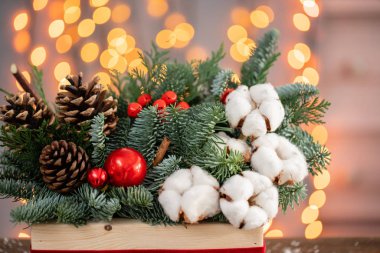 Kırsal ahşap bir kutuda taze ladin aranjmanı. Noel havası. Bokeh of Garland, arka planda lambalar.