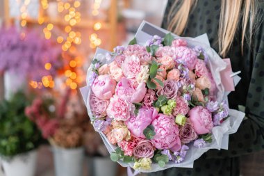 Pembe şakayıklar, Sarah Bernhardt ve farklı çiçekler. Avrupa çiçekçisi. Kadınların elinde güzel bir buket. Çiçekçi dükkanındaki çiçekçinin işi. Taze kesilmiş çiçek getirdim..
