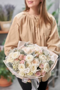 Modern çiçekçi dükkanı. Çiçekçinin işini bitirdim. Kadınların elinde güzel bir buket karışık çiçek. Taze kesilmiş çiçek getirdim..