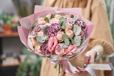 Modern çiçekçi dükkanı. Çiçekçinin işini bitirdim. Kadınların elinde güzel bir buket karışık çiçek. Taze kesilmiş çiçek getirdim..