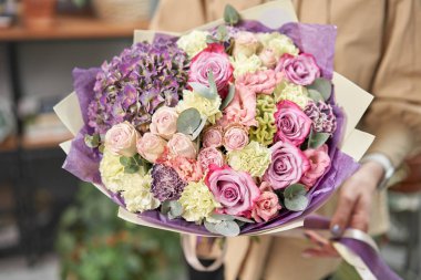 Modern çiçekçi dükkanı. Çiçekçinin işini bitirdim. Kadınların elinde güzel bir buket karışık çiçek. Taze kesilmiş çiçek getirdim..