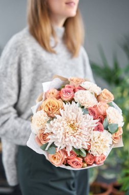 Avrupa çiçekçisi. Kadınların elinde güzel bir buket karışık çiçek. Çiçekçi dükkanındaki çiçekçinin işi. Taze kesilmiş çiçek getirdim..