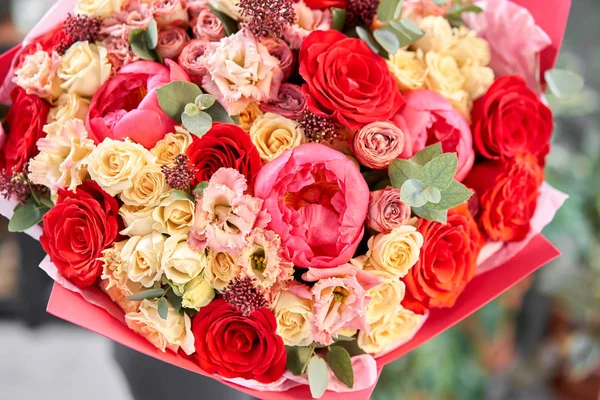 Rottöne Schöner Strauß gemischter Blumen in Frauenhänden. die Arbeit des Blumenhändlers in einem Blumenladen. Schöner frischer Strauß. Blumenlieferung — Stockfoto
