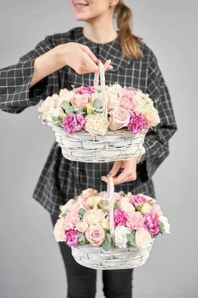 Dos arreglos de flores en canasta de mimbre. Tienda floral moderna. Trabajo terminado de la floristería. Lindo ramo de flores mixtas en manos de mujeres. Entrega flor fresca cortada de la tienda en línea — Foto de Stock