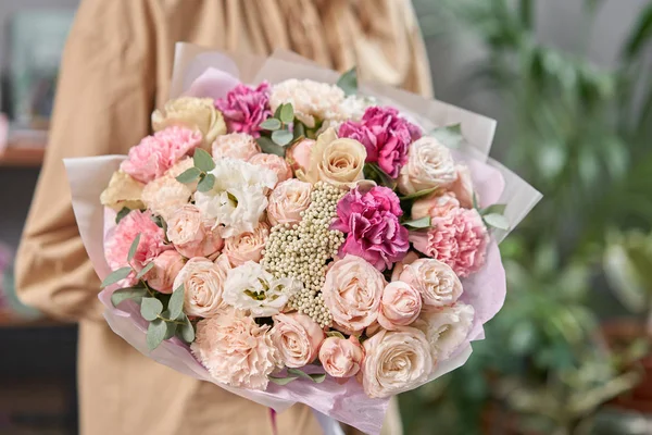 Modern floral shop. Finished work of the florist. Cute bouquet of mixed flowers in womans hands. Delivery fresh cut flower. — Stock Photo, Image