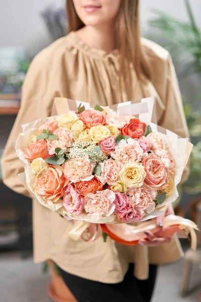 Loja floral moderna. Terminou o trabalho da florista. Buquê bonito de flores mistas em mãos de mulheres. Entrega flor de corte fresco . — Fotografia de Stock