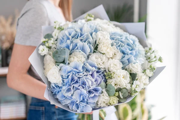 Tienda floral europea. Hermoso ramo de flores mixtas en manos de mujeres. el trabajo de la floristería en una florería. Entrega flor fresca cortada . — Foto de Stock