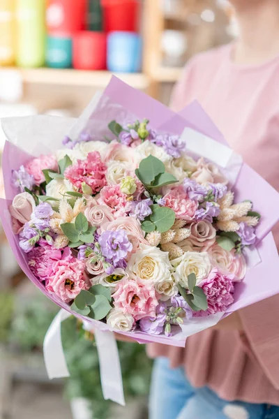 Tienda floral europea. Hermoso ramo de flores mixtas en manos de mujeres. el trabajo de la floristería en una florería. Entrega flor fresca cortada . — Foto de Stock