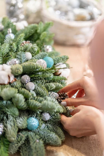 Uma mulher decora um arranjo de Natal. Mãos à vista. Master class em fazer ornamentos decorativos. Decoração de Natal com suas próprias mãos. A celebração do ano novo. Loja de flores — Fotografia de Stock