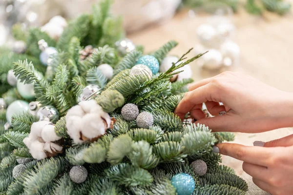 Een vrouw versiert een kerstversiering. Handen van dichtbij. Masterclass over het maken van decoratieve ornamenten. Kerstdecor met eigen handen. Het nieuwjaarsfeest. Bloemenwinkel — Stockfoto