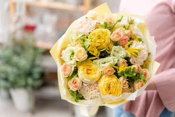 Tienda floral europea. Hermoso ramo de flores mixtas en manos de mujeres. el trabajo de la floristería en una florería. Entrega flor fresca cortada . — Foto de Stock