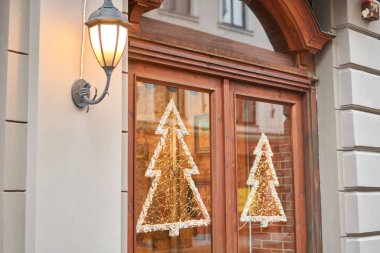 Eski bir Avrupa şehrinde bir Noel gününde sokak. Lambalar, Noel süsleri ve dekorasyonlar. Mağaza vitrininin veya restoranın dekorasyonu.