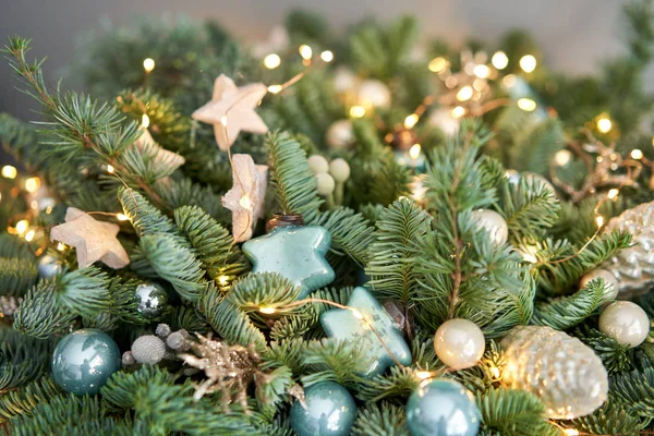 Grande arranjo de abeto fresco em uma cesta de vime. Decorado com bolas azuis, cones e pequenas estrelas. Humor de Natal. lâmpadas Garlands — Fotografia de Stock