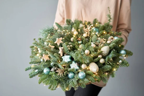 Groot arrangement van verse sparren in een rieten mandje. Kerststemming. Mooi boeket in vrouwenhanden.. — Stockfoto