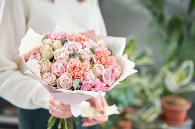 Avrupa çiçekçisi. Kadınların elinde güzel bir buket karışık çiçek. Çiçekçi dükkanındaki çiçekçinin işi. Taze kesilmiş çiçek getirdim..