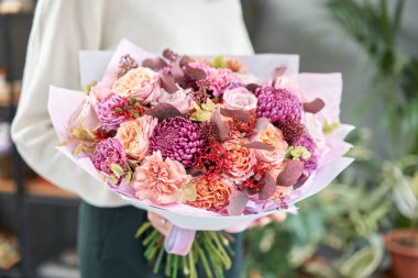 Avrupa çiçekçisi. Kadınların elinde güzel bir buket karışık çiçek. Çiçekçi dükkanındaki çiçekçinin işi. Taze kesilmiş çiçek getirdim..