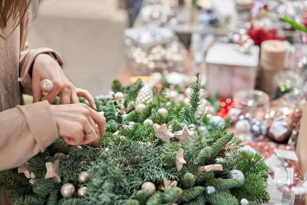 Una donna decora un accordo natalizio. Master class sulla realizzazione di ornamenti decorativi. Decorazione natalizia con le proprie mani. La celebrazione del nuovo anno. Negozio di fiori — Foto Stock