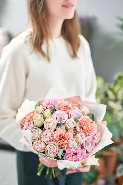 Tienda floral europea. Hermoso ramo de flores mixtas en manos de mujeres. el trabajo de la floristería en una florería. Entrega flor fresca cortada . — Foto de Stock