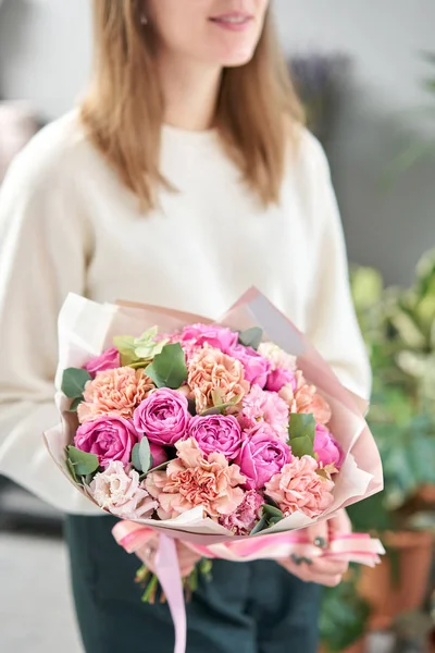 European floral shop. Beautiful bouquet of mixed flowers in womans hands. the work of the florist at a flower shop. Delivery fresh cut flower. — Stock Photo, Image