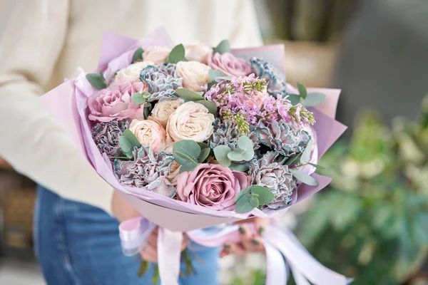 Avrupa çiçekçisi. Kadınların elinde güzel bir buket karışık çiçek. Çiçekçi dükkanındaki çiçekçinin işi. Taze kesilmiş çiçek getirdim..