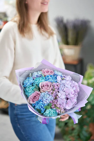 Loja floral europeia. Belo buquê de flores mistas em mãos de mulheres. o trabalho da florista em uma loja de flores. Entrega flor de corte fresco . — Fotografia de Stock