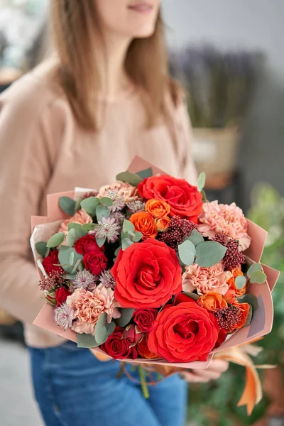 欧洲花店。女人手里拿着一束美丽的混合花。花店花商的工作。运送新鲜切花. — 图库照片