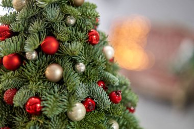 Tahta masanın üzerinde küçük, güzel bir Noel ağacı. Mutlu ruh hali. Arka planda çelenk var. Duvar kağıdı. Danimarka çamı ve köknar, Nobilis
