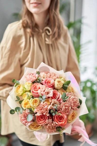 Loja floral europeia. Belo buquê de flores mistas em mãos de mulheres. o trabalho da florista em uma loja de flores. Entrega flor de corte fresco . — Fotografia de Stock