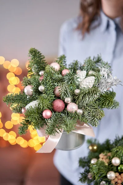 Dois pequenos arranjos de abeto fresco em um pote de metal. Humor de Natal. Bokeh de luzes de guirlanda no fundo . — Fotografia de Stock