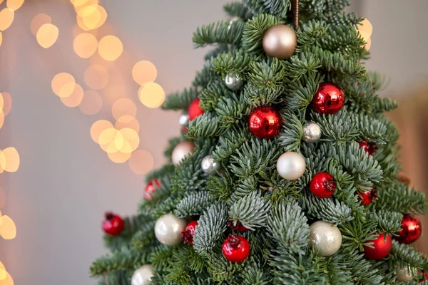 Bela árvore de Natal pequena na mesa de madeira. Bom humor. Lâmpada de guirlanda bokeh no fundo. Papel de parede. Pinheiro e abeto dinamarqueses, Nobilis — Fotografia de Stock